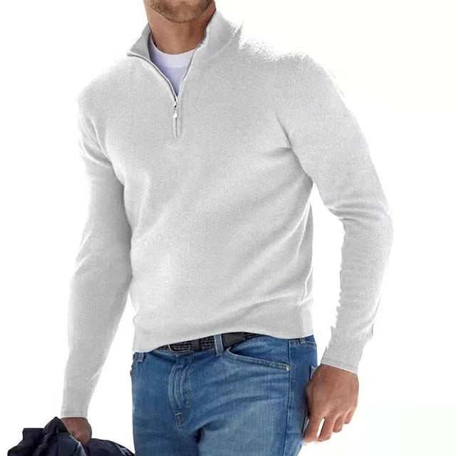 Man modelling a white quarter-zip jumper with half-zip neckline, worn over a white t-shirt with jeans and a belt.