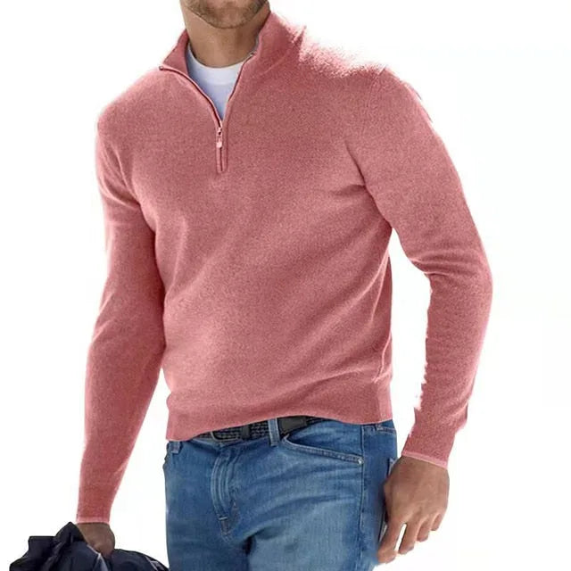 Man wearing a dusty pink quarter-zip jumper with the zip partly open, showing the layered t-shirt underneath.
