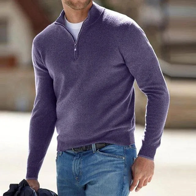 Outdoor shot of a man in a heathered purple quarter-zip jumper with long sleeves, worn casually with denim.