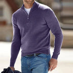 Outdoor shot of a man in a heathered purple quarter-zip jumper with long sleeves, worn casually with denim.