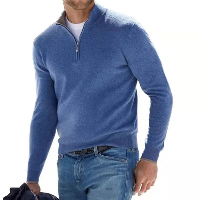 Man in a denim blue quarter-zip jumper with contrast ribbed trim at the collar and cuffs, paired with jeans.