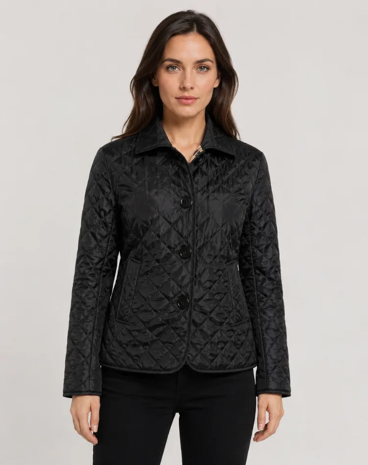 Front view of black diamond-quilted jacket with collar and button fastening, worn with black jeans
