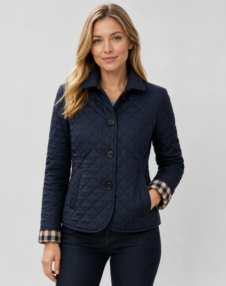 Navy quilted jacket with buttoned collar and checked cuffs, worn with dark denim jeans