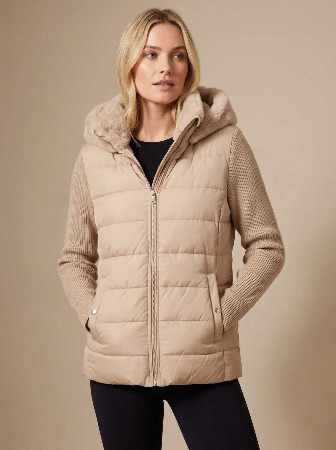 Beige quilted puffer jacket with faux fur hood trim, ribbed knit sleeves and side snap pockets, worn open over black top