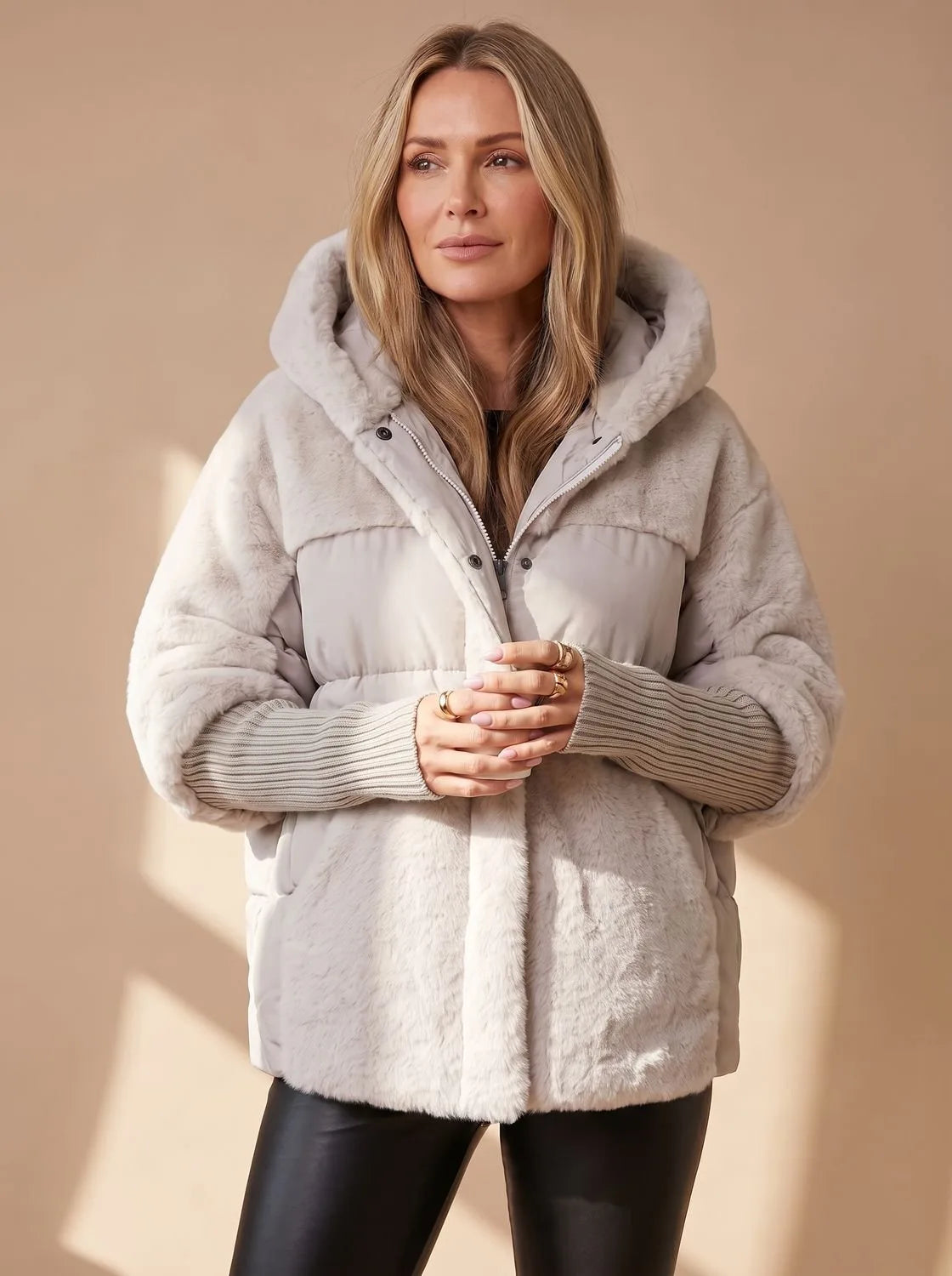 Close front view of grey faux fur hooded puffer jacket showing quilted panel, zip and snap closure detail