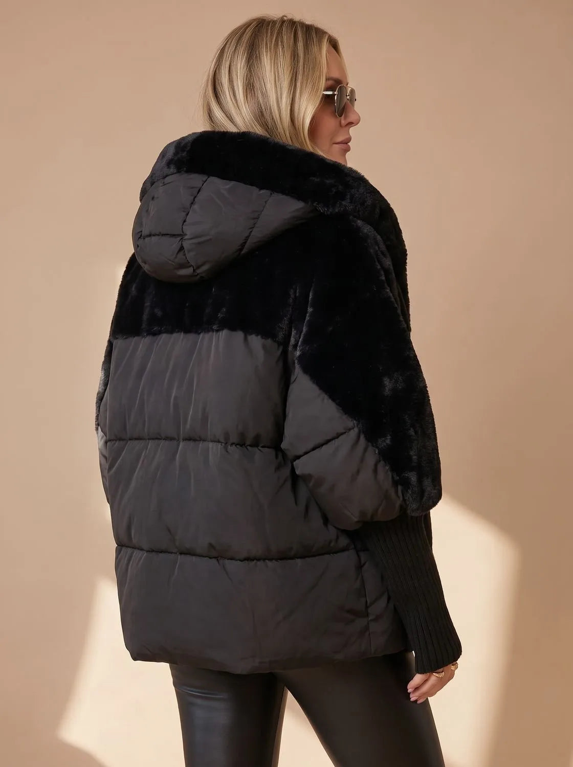 Back view of black faux fur puffer jacket showing hood, quilted lower panel and ribbed knit sleeve