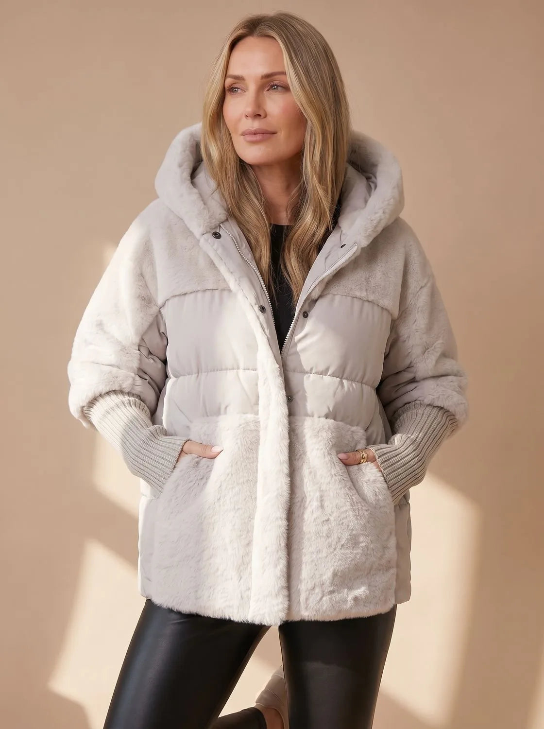 Front view of light grey and cream faux fur puffer jacket with hood down around shoulders, worn with sunglasses