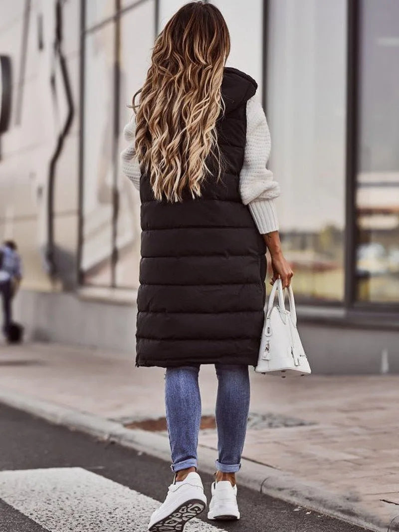Back view of a black quilted longline gilet showing the horizontal channel stitching and hood