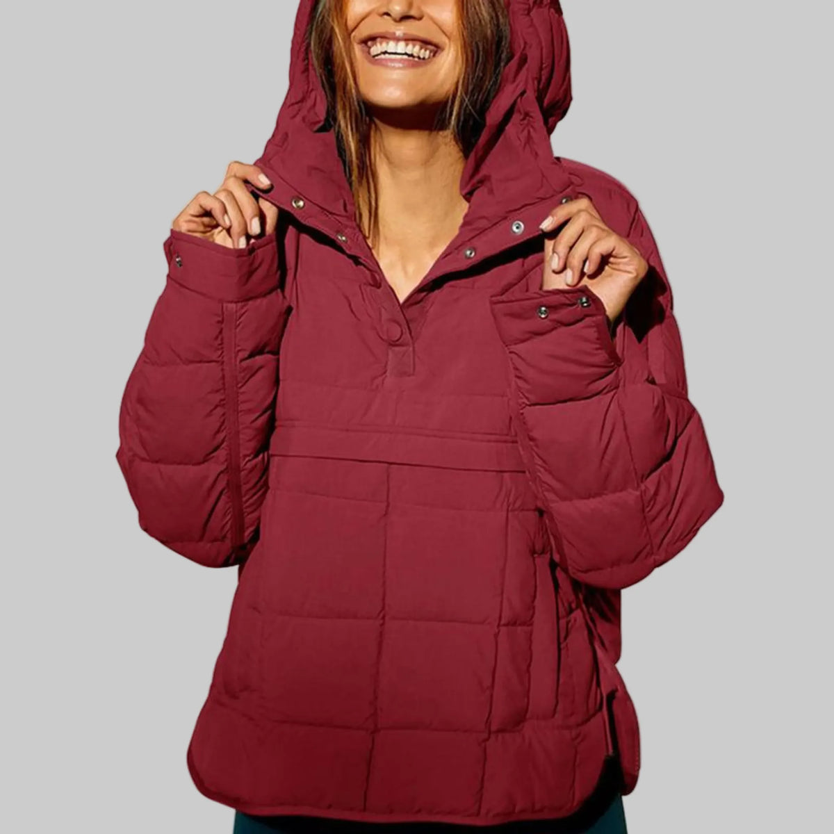 Wine red quilted anorak with hood raised, hands holding open the snap-button collar