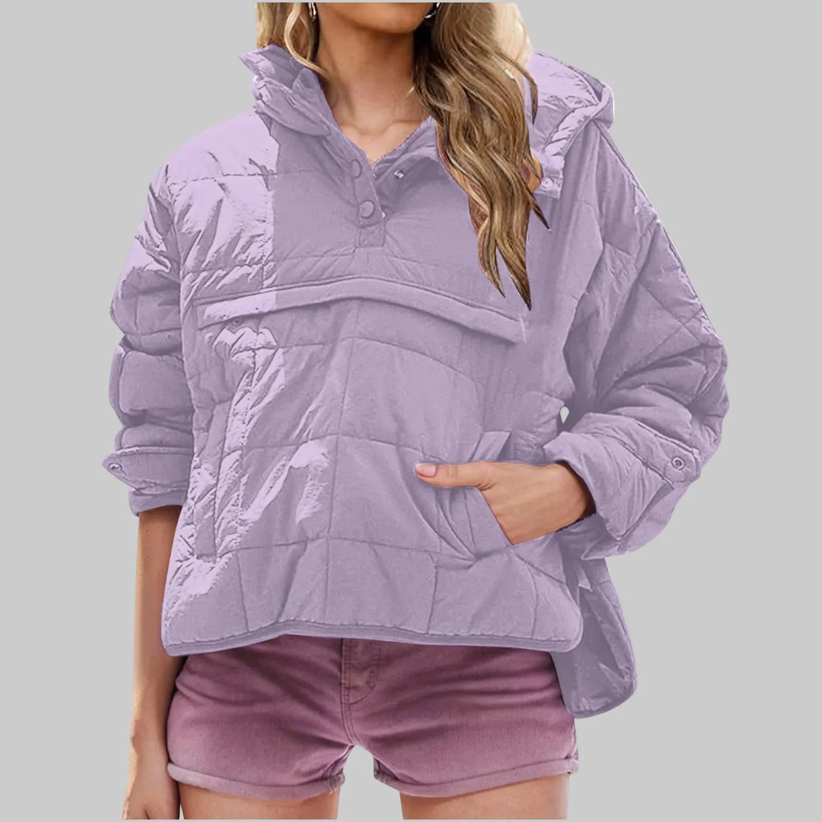 Orange quilted pullover jacket close-up showing square quilted panels and long sleeve with snap cuff