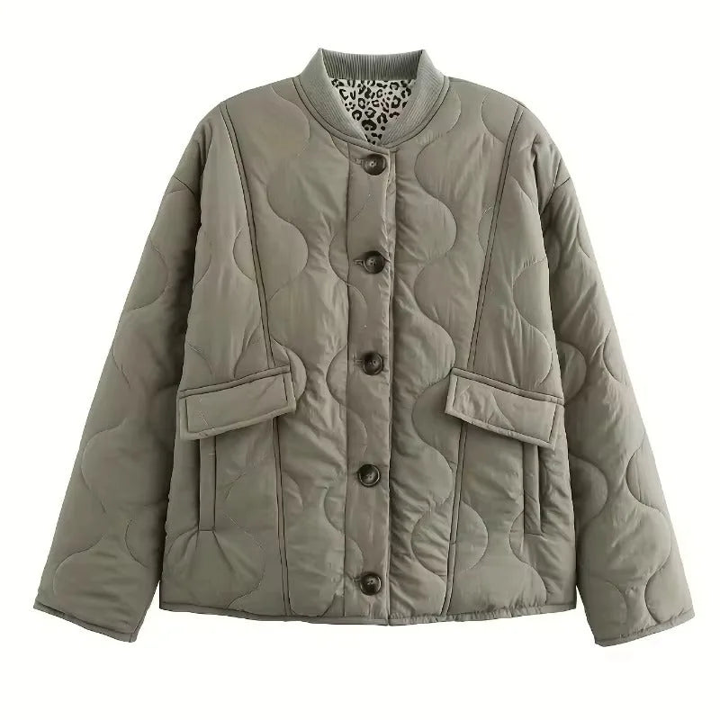 Flat lay of a sage green quilted jacket with dark buttons and a glimpse of the leopard print inner lining