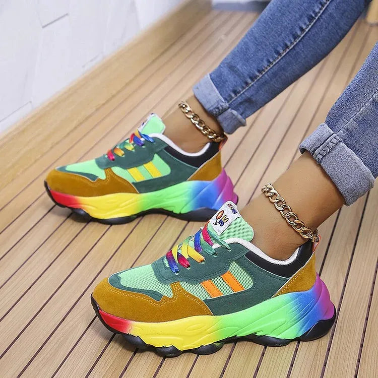 Side profile of green and mustard suede chunky trainers with rainbow outsole and multicoloured laces
