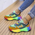 Side profile of green and mustard suede chunky trainers with rainbow outsole and multicoloured laces