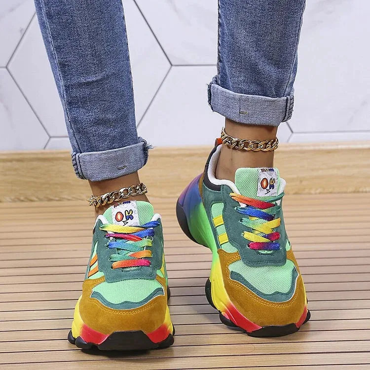 Back view of green and mustard chunky trainers worn with cuffed jeans, showing heel construction and sole