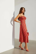 Close side view highlighting the fine straps, ruched bust detail and delicate floral print on red fabric
