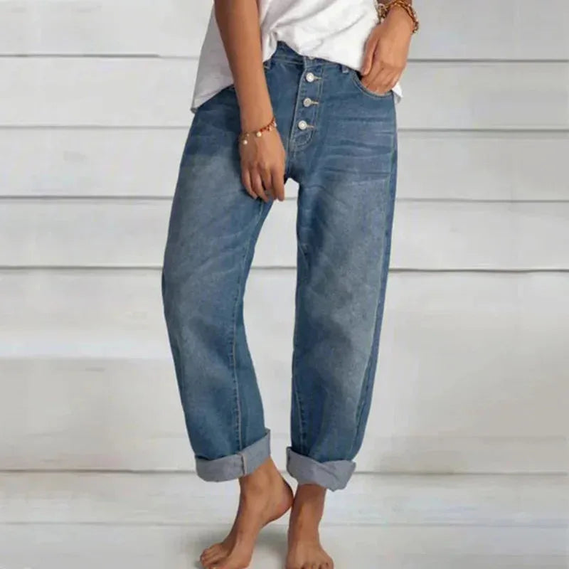 Front view of button-fly denim jeans in mid-blue wash, showing turned-up cuffs and relaxed leg silhouette