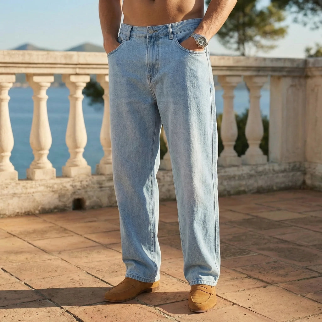 Front view of light blue washed denim jeans with a roomy straight leg, paired with tan suede loafers