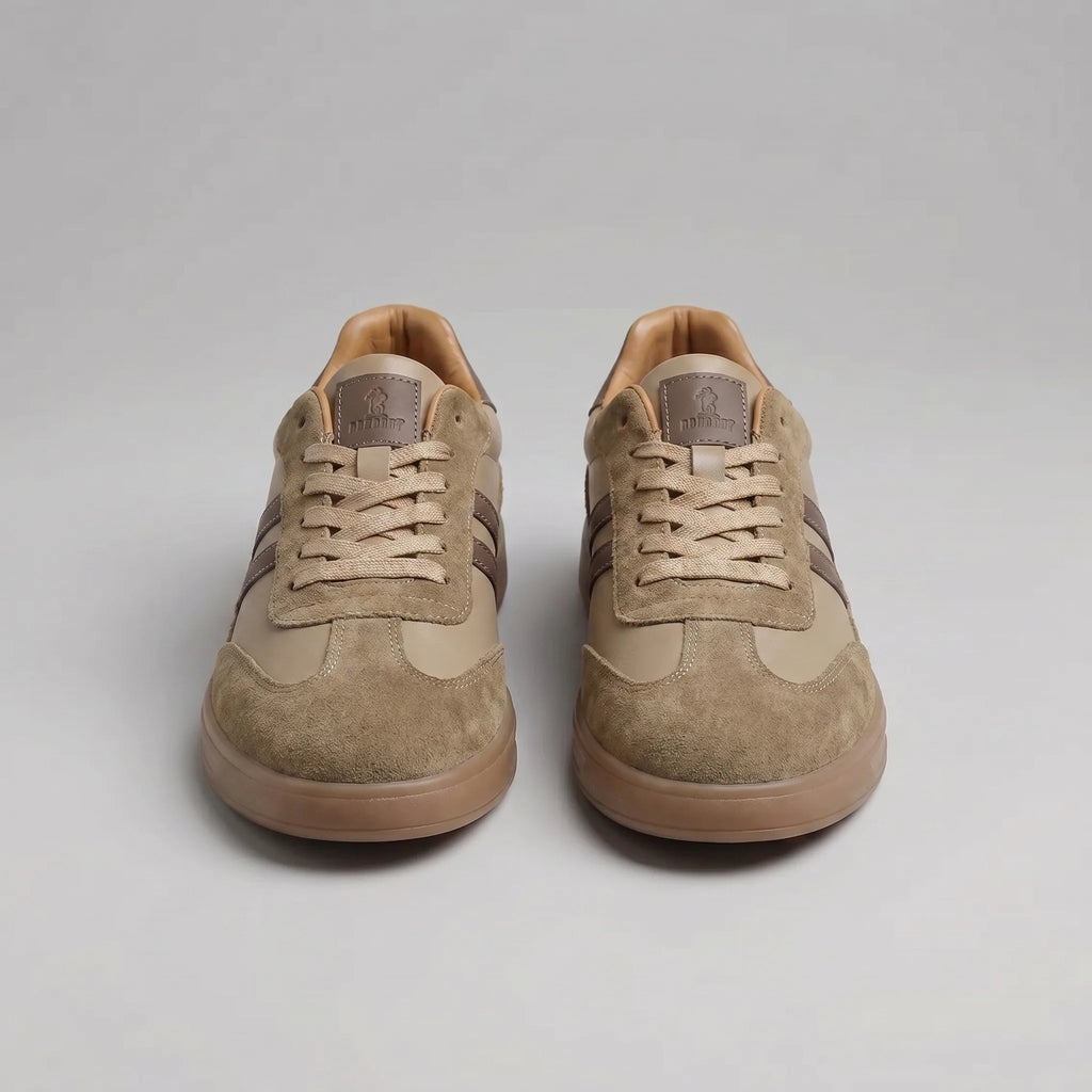 Close detail of the brown trainer's stitched stripes, suede trim and ridged gum outsole