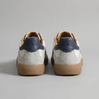 Back view of both trainers showing navy heel tabs with embossed logo and grey suede heel counters