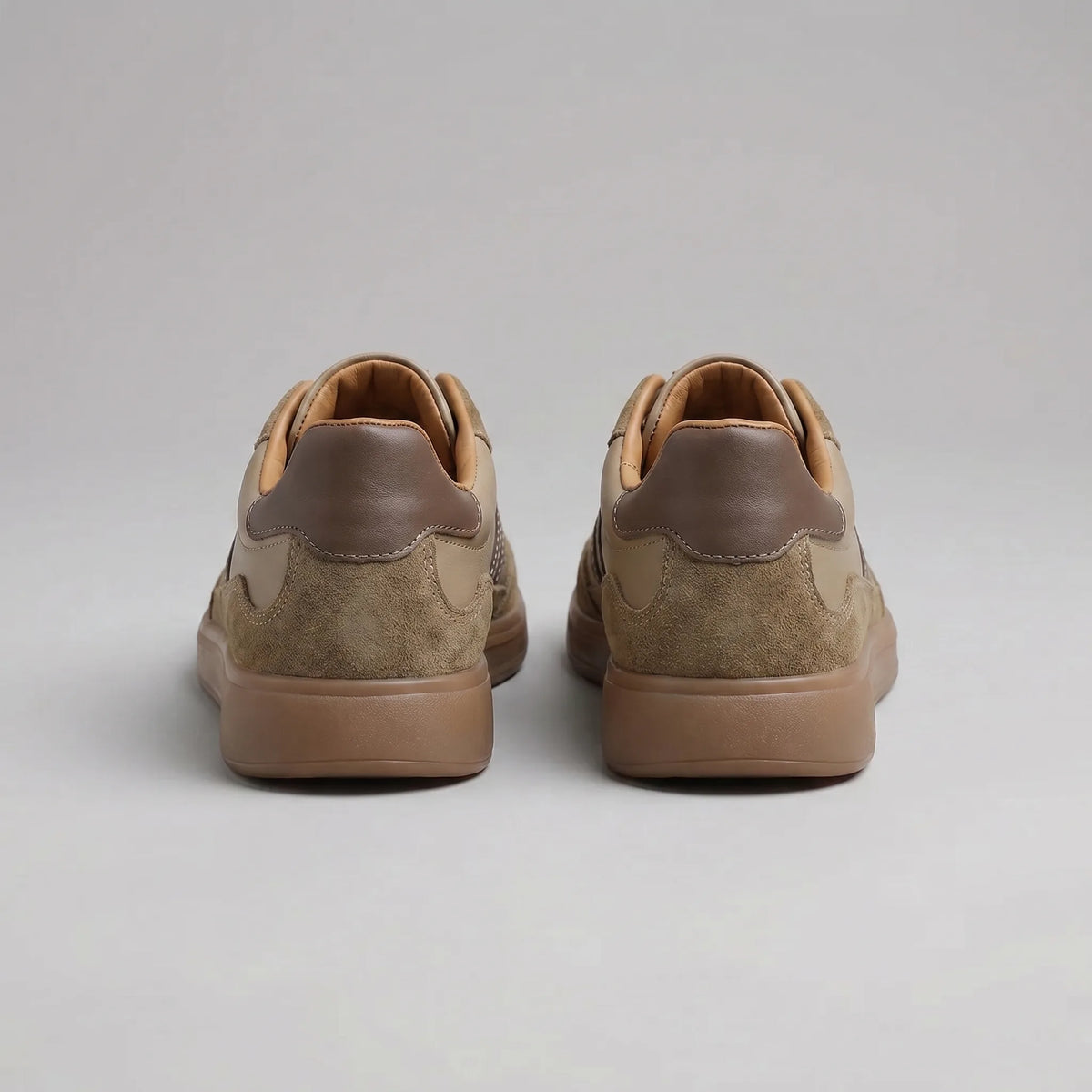 Back view of brown trainers showing the dark brown heel tabs and tan leather inner lining