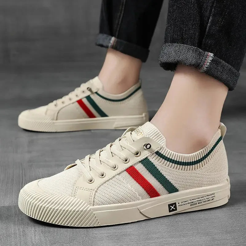 Beige striped sneaker worn on foot, styled with rolled-up dark jeans