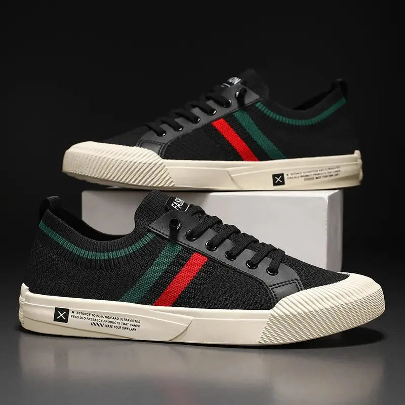 Pair of black knit sneakers with contrast stripe shown together against dark background