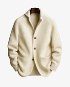 Ivory ribbed knit tailored cardigan with button front and patch pockets on a wooden hanger