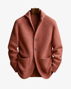 Terracotta pink ribbed knit cardigan with patch pockets and button placket on a hanger