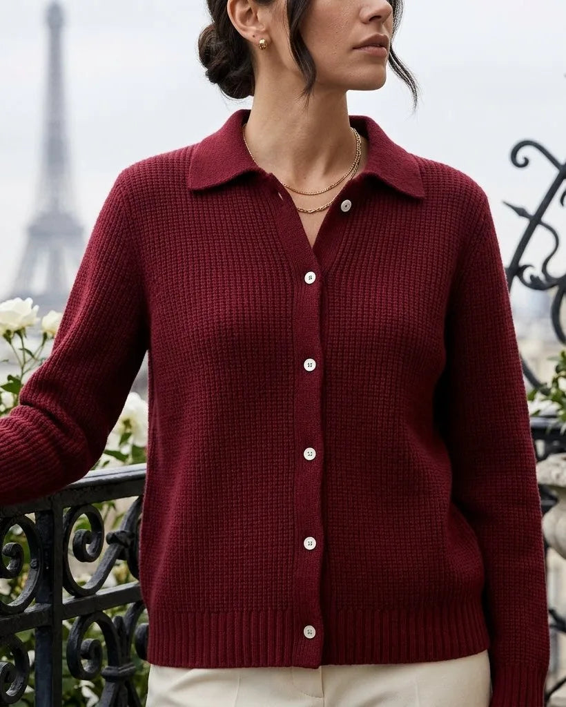 Close-up of a woman wearing a deep red ribbed knit cardigan with collar and mother-of-pearl buttons on a Paris balcony