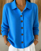 Close-up front view of a bright blue ribbed knit cardigan with brown wooden buttons and a collared polo neckline