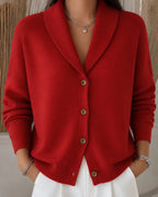 Front view of a red ribbed knit cardigan with a shawl-style collar and wooden button placket, worn open at the neck