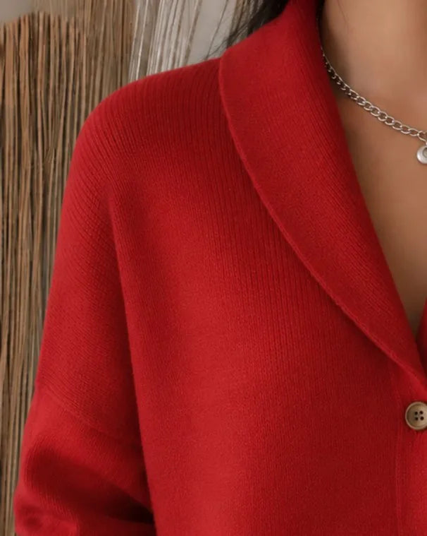 Close-up of the red cardigan's shawl collar and top button, showing the soft ribbed knit fabric