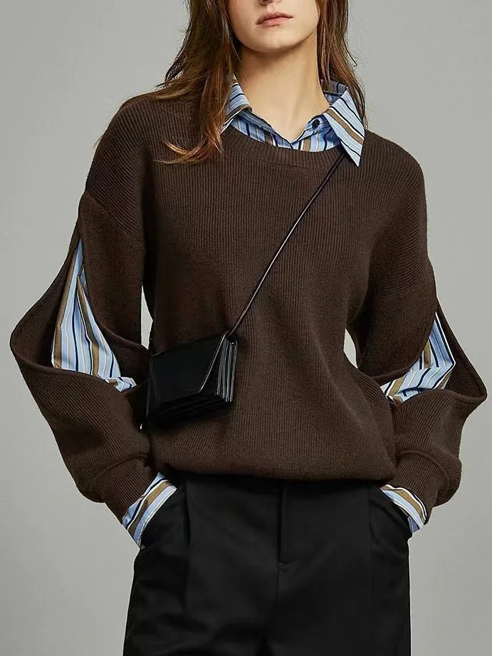 Front view of a woman wearing a dark brown ribbed jumper layered over a blue striped shirt with a cut-out sleeve detail