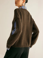 Back view of the dark brown ribbed jumper showing the relaxed fit and striped shirt sleeve through the cut-out