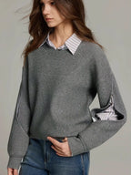 Grey ribbed knit jumper worn over a striped shirt, front view with hand resting at the waist