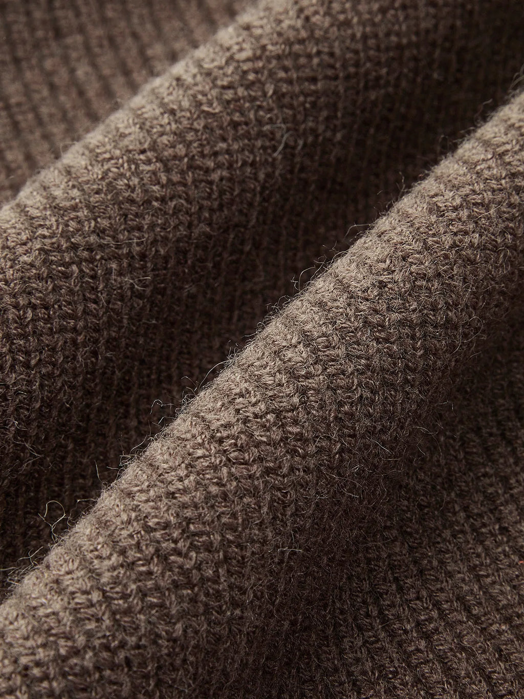 Macro shot of the dark brown knit fabric texture showing the soft ribbed weave up close