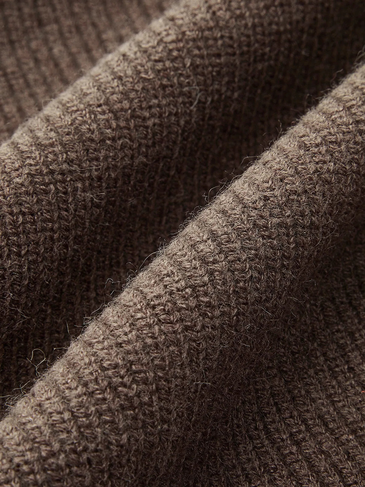 Macro shot of the dark brown knit fabric texture showing the soft ribbed weave up close