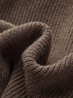 Close-up of the dark brown ribbed cuff and fabric folds highlighting the knit's soft, textured finish