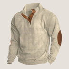 Side angle of beige corduroy-knit quarter-zip jumper showing mock collar and suede elbow patch