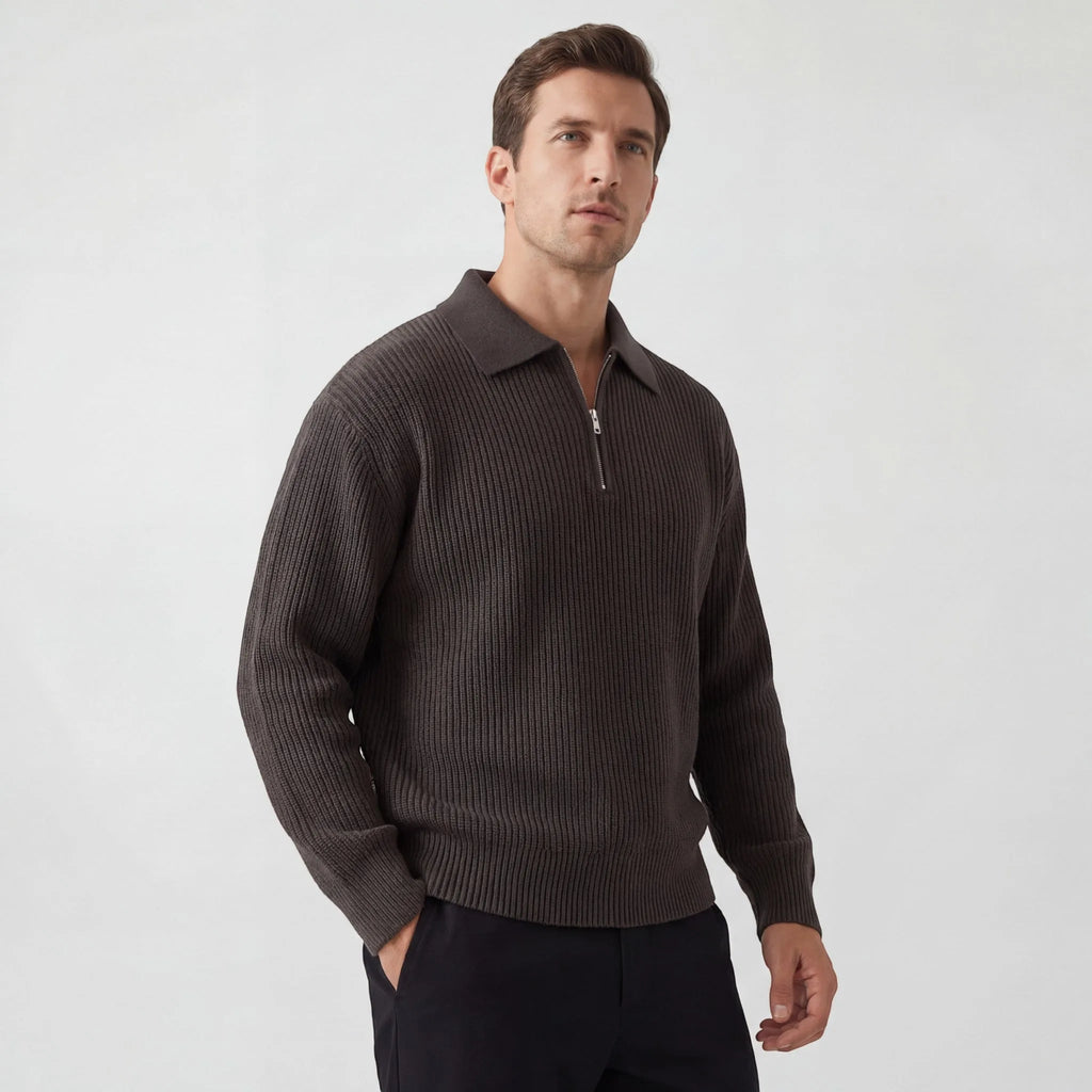Side view of a man wearing a dark brown ribbed knit zip jumper with collar, paired with black trousers