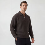 Side view of a man wearing a dark brown ribbed knit zip jumper with collar, paired with black trousers