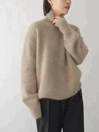 Side profile of a khaki roll neck jumper with relaxed fit and folded high collar