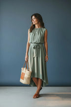 Close-up front view highlighting the gathered round neckline, delicate necklace and bow-tied waist of the sage green dress.