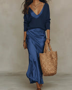 Full-length view of the flowing satin maxi skirt and matching jumper set with straw tote and strappy sandals