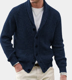 Close view of a navy blue ribbed knit shawl-collar cardigan with front buttons worn over a white top