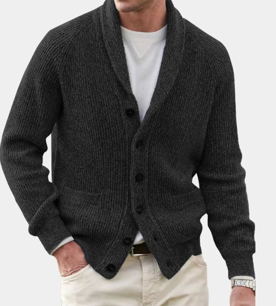 Charcoal grey shawl-collar cardigan in chunky ribbed knit, fastened with dark buttons and patch pockets