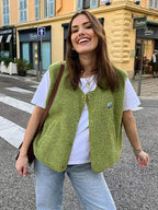Close-up of the textured green teddy fleece body warmer with brand patch and popper fastenings