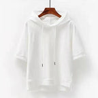White short-sleeve hoodie on a hanger, full front view showing the loose fit and cuffed sleeves