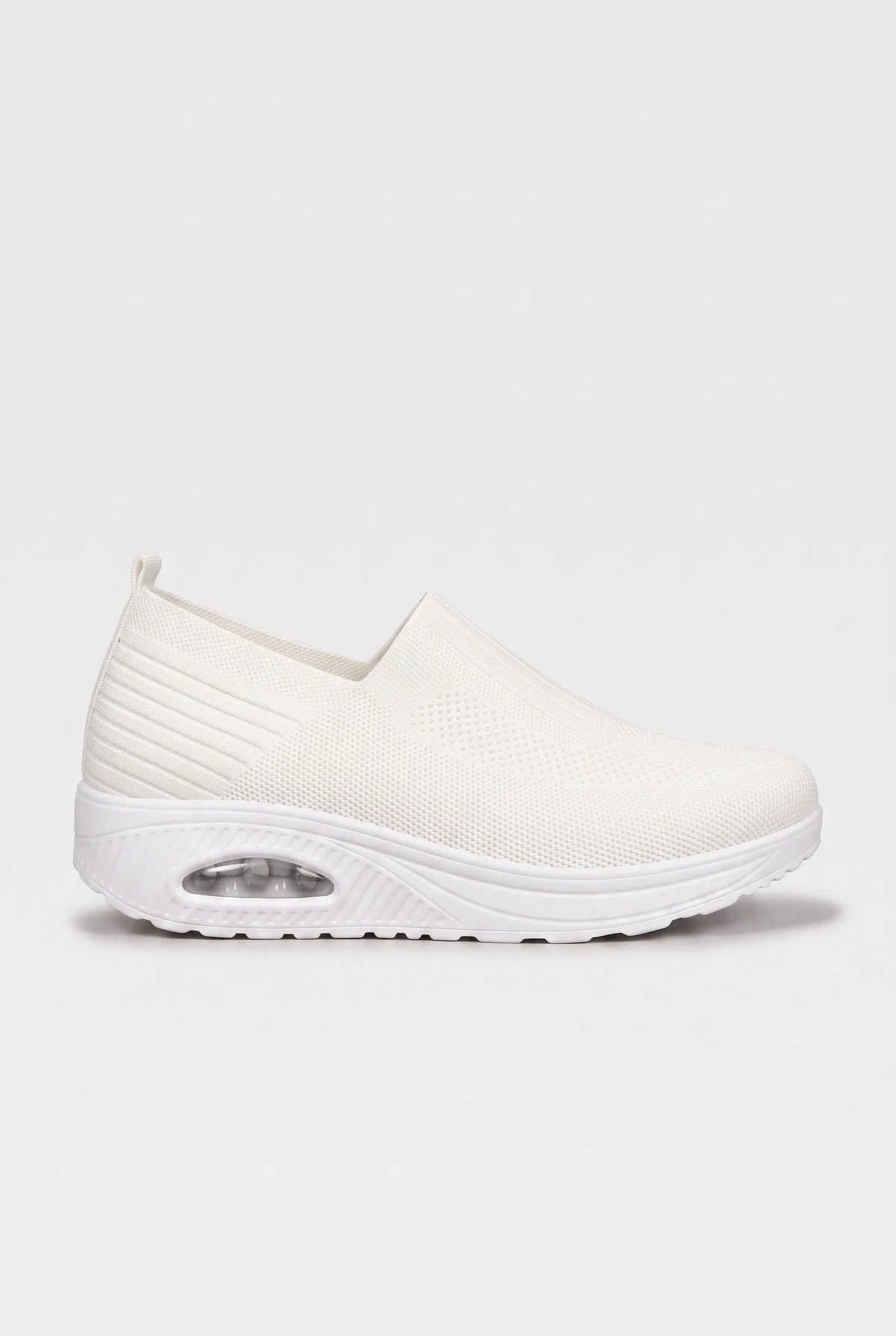 Side profile of white knit slip-on trainer with matching white cushioned wedge sole