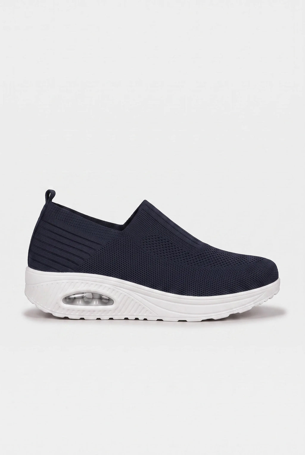 Side profile of navy blue knit slip-on trainer with contrasting white wedge sole and air-bubble unit